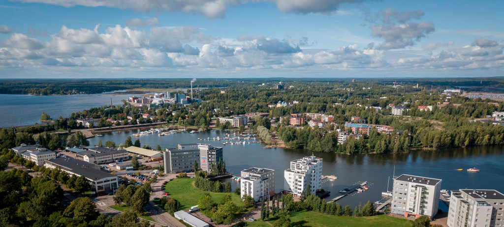 Ilmakuva Kotkan kaupungista. Kuvassa kerrostaloja vehreässä maastossa, jonka ympärillä merta.