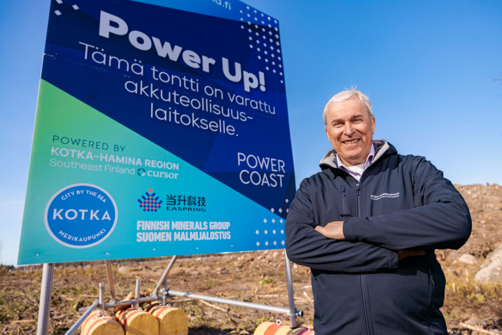 Mies ison akkuklusteria markkinoivan kyltin edessä.